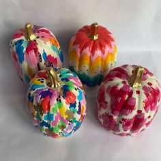 three painted pumpkins sitting next to each other