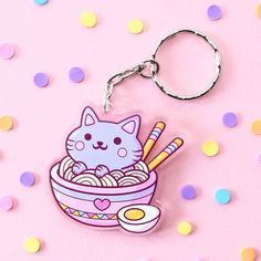 a cat in a bowl of noodles with chopsticks on it and confetti scattered around