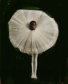 a woman in a white dress is standing under an umbrella