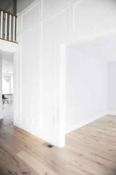 an empty room with hard wood floors and white walls