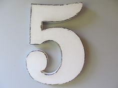 the number five is painted white and sits on a wall