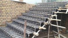 several steel bars are stacked on top of each other in front of a brick wall