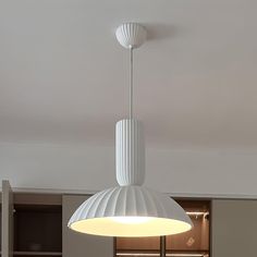 a white lamp hanging from the ceiling in a room