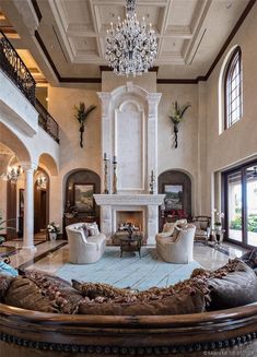 a large living room with two couches and a fireplace in the middle of it