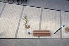 an overhead view of a bench and tree in the middle of a tiled floor area