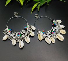 Adorn your daily attire with ethnicity & add glam to your personality with this high-quality handcrafted shell earrings. Compliment your outfit with this set of Indian jewellery on any given day and dazzle people with your elegant aura. You'll be sure to receive compliments when you wear this exquisite piece of german jewellery. Pair it up with any attire & make sure to brighten up your outfit on any given day. You can also put on this set with semi- formal attire to make you feel the best versi Traditional Nickel-free Danglers, Oxidized Finish Chandbali Hoop Earrings, Cowrie Shell Earrings, Traditional Cowrie Shell Jewelry For Beach, Traditional Cowrie Shell Jewelry, Bohemian White Cowrie Shell Earrings, Beach-style Cowrie Shell Earrings, Bohemian Jewelry With Shell-shaped Cowrie Shell, German Jewelry