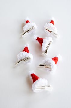 six red and white hair clips with santa hats on them