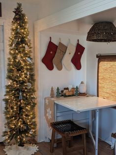 christmas stockings hung on the wall next to a small table with stools under it