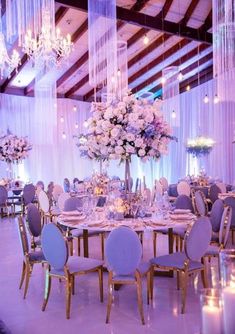 an elegant wedding reception set up with purple and white flowers