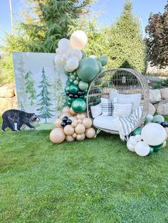 a birdcage filled with balloons sitting on top of a green grass covered field