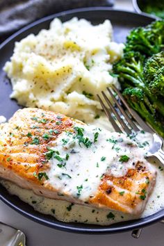 a plate with chicken, mashed potatoes and broccoli on it next to a fork