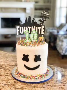 a birthday cake decorated with sprinkles and a happy face