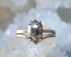 a close up of a ring on top of a piece of rock with ice in the background