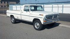 a white pickup truck parked in a parking lot next to a fenced off area