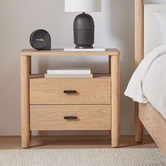 a night stand with two drawers and a lamp on the end table next to it