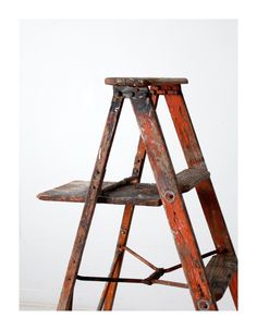 an old wooden step ladder leaning against a wall with no one on it's feet