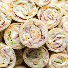 a pile of rolls filled with different types of food