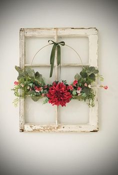 an old window frame with flowers and greenery