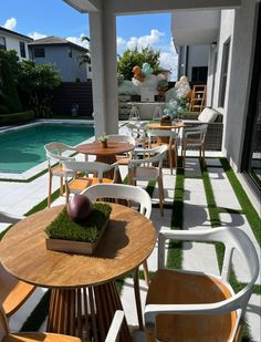 an outdoor patio with tables and chairs next to a pool