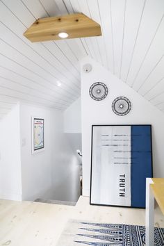 a room with white walls and wood floors, including a blue rug on the floor