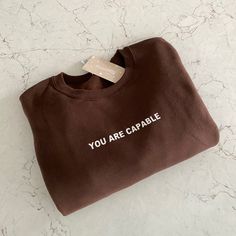 You Are Capable | Positive Affirmations Sweatshirt Unisex Sizing. Handmade By Me! Color: Chocolate Masculine Fits, Dark Chocolate Color, Brown Crewneck, Hoodie Quotes, Brown Sweatshirt, Brown Hoodie, Club Sweatshirts, Color Chocolate, Chocolate Color