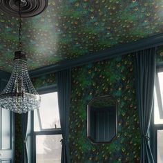 a room with a chandelier hanging from the ceiling and green wallpaper on the walls