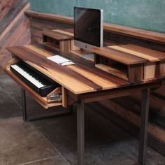 a computer desk with a keyboard and monitor on it in front of a chalkboard