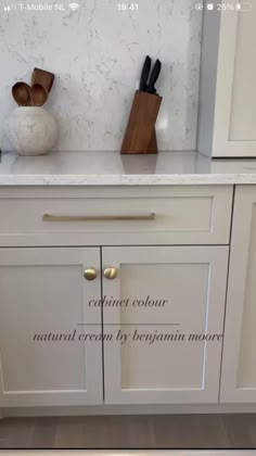 a kitchen with white cabinets and marble counter tops, including knives on the cabinet doors