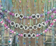 the words in my birthday era spelled out with beads and confetti on a string