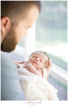 a man holding a sleeping baby in his arms