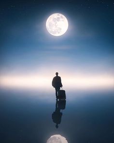 a man standing in the middle of water with a suitcase under a full moon behind him