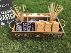 some crackers and marshmallows are in a box on the grass