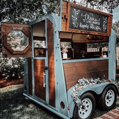 a food truck is parked in the grass with its door open and writing on it's side