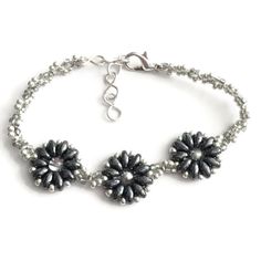 An Adorable Beaded Bracelet Handmade With Dark Metallic Superduo Beads And Two Intertwined Tones Of Seed Beads. The Dark Gray And Silver Seed Beads Form A Twist Pattern Between Neutral Colored Flowers With Silver Glass Centers. Adjustable From 7 To 8 Inches. Item May Vary Slightly From The One Shown. Not Intended For Children Under 12. Superduo Bracelet, Twist Pattern, The One Show, Silver Bead Bracelet, Womens Jewelry Bracelets, Handmade Bracelets, Seed Beads, Jewelry Crafts, Beaded Bracelets