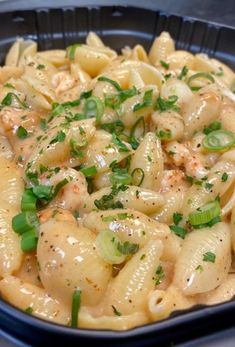 a bowl filled with pasta covered in sauce and garnished with green onions