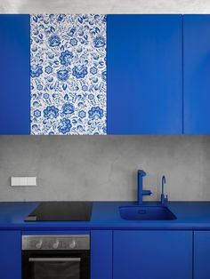 a kitchen with blue cabinets and a sink next to a counter top that has a faucet on it