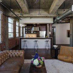 a living room filled with furniture next to a kitchen and an open concept dining area