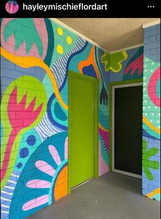 an open door in front of a colorful wall