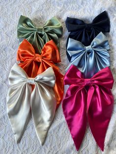 Introducing our trending Silky Satin Hair Bows, the standout accessory that exudes sophisticated appeal. Combining style and functionality, these hair bows are perfect for any occasion. Each bow features an attached 3" hair clip, with tails measuring 7 1/2" long and a width of 7". Available in Navy, Black, Ivory, Sage, Orange, Fuchsia and Light Blue, they add a touch of elegance to any outfit. Custom orders are always welcome, making our hair bows an ideal gift she'll cherish. Upgrade her hair a Satin Bow Hair Clips, Bow Tie For Hair, Cute Bows For Hair, Trending Hair Accessories, Satin Hair Accessories, Bow For Hair, Bows For Hair, Satin Accessories, Hair Bow Tie