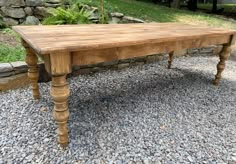 a wooden table sitting on top of gravel covered ground