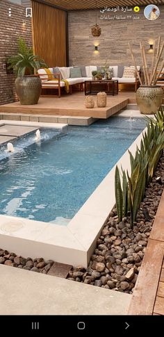 an outdoor swimming pool surrounded by rocks and plants