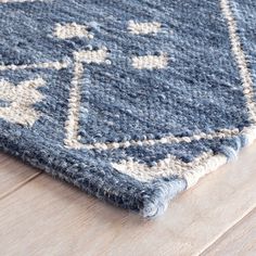 a blue and white rug on top of a wooden floor