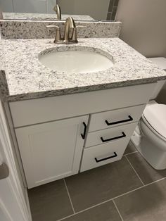 a bathroom with a sink, toilet and mirror in it's center piece is shown