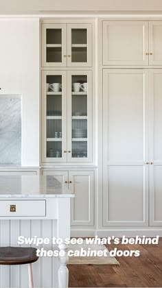 a kitchen with white cabinets and wood floors