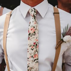 a man wearing suspenders and a floral tie