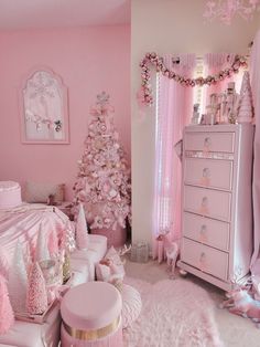 a bedroom decorated in pink and white with a christmas tree next to the dressers