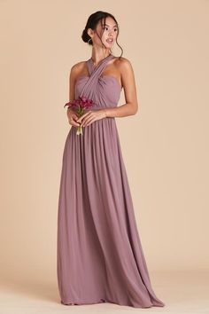 a woman in a long purple dress holding a flower