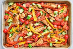 chicken and veggies in a pan with tomatoes, zucchini, bell pepper, cucumber, tomato, yellow peppers