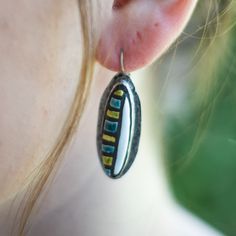 a close up of a person's ear with earrings hanging from the end of it