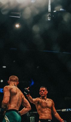 two men standing next to each other in a boxing ring